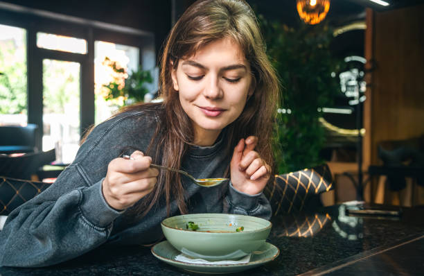 mujer comiendo caldo de huesos