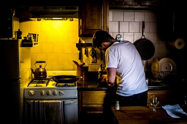 hombre cocinando sarten acero inoxidable