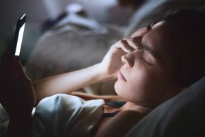 mujer en cama con movil